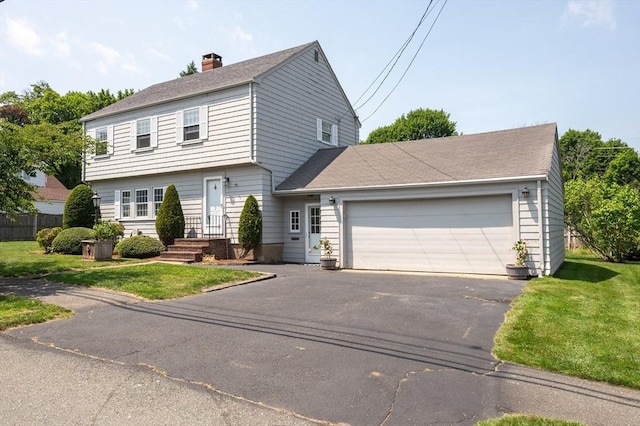 2 Proctor Cir, Peabody, MA 01960 - colonial home featuring a garage, asphalt driveway, a front lawn, and a chimney