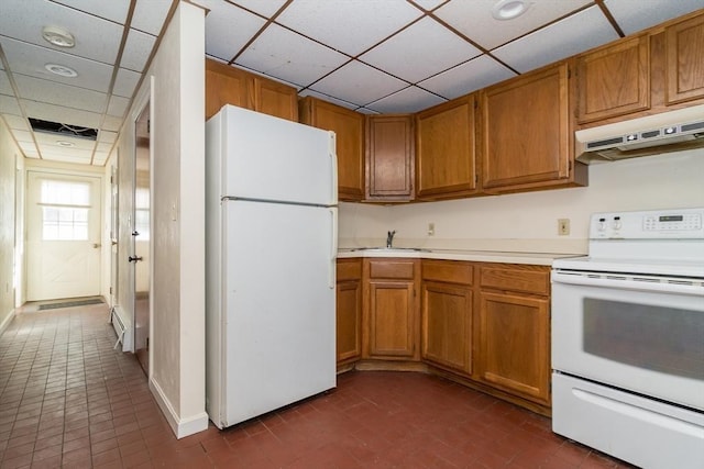 kitchen with a drop ceiling, sink, white appliances, and dark tile patterned floors