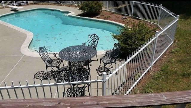 view of pool featuring a diving board and a patio