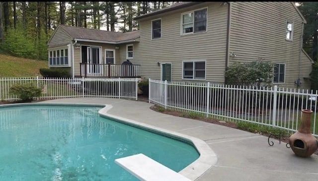 view of swimming pool featuring a diving board