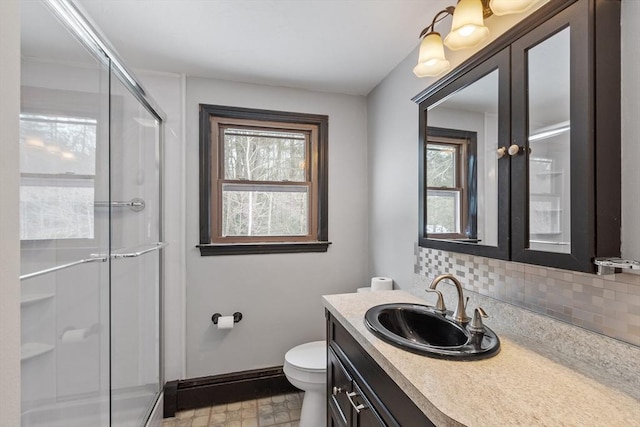 full bath featuring vanity, a shower stall, a wealth of natural light, and decorative backsplash