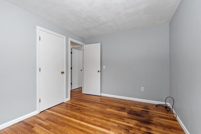 unfurnished room featuring wood finished floors and baseboards