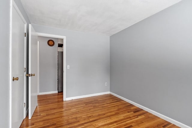 unfurnished room featuring wood finished floors and baseboards