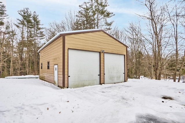 snow covered garage with a garage