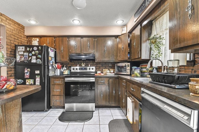288 Norman St, Fall River, MA 02721 - kitchen with appliances with stainless steel finishes, under cabinet range hood, dark countertops, light tile patterned flooring, and backsplash