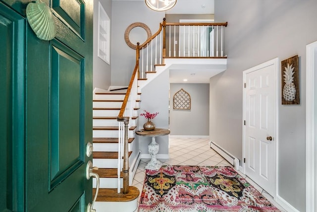 tiled foyer entrance featuring a towering ceiling and a baseboard radiator