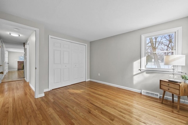 bedroom with a fireplace, light hardwood / wood-style flooring, and a closet