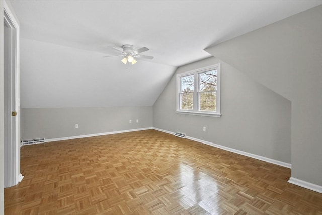 bonus room with vaulted ceiling, parquet flooring, and ceiling fan