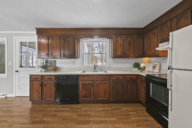 kitchen featuring dark hardwood / wood-style flooring, sink, black appliances, and a textured ceiling