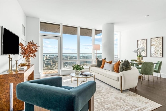 living area with a wall of windows, wood finished floors, and baseboards