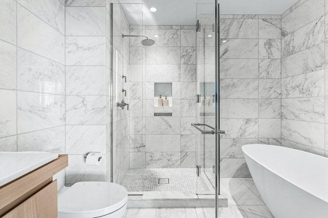 bathroom featuring tile walls, a freestanding tub, a shower stall, and vanity