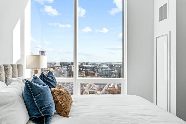 bedroom featuring visible vents and a city view