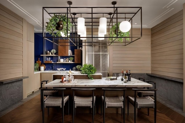 dining area featuring ornamental molding and wood walls