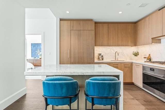 kitchen with appliances with stainless steel finishes, modern cabinets, a sink, and tasteful backsplash