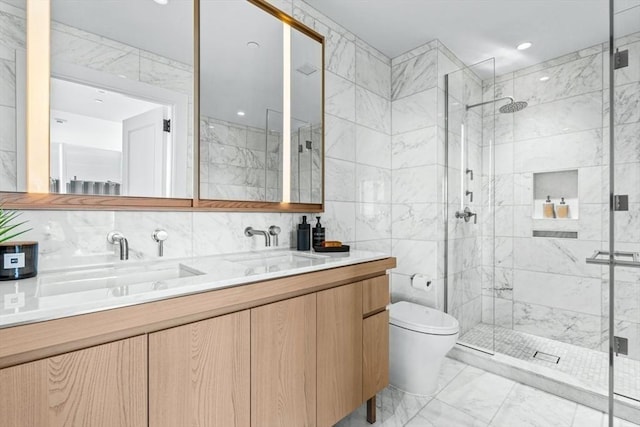 bathroom with toilet, marble finish floor, a shower stall, and tile walls