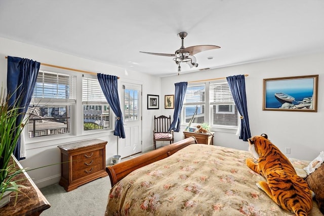 bedroom with ceiling fan, carpet, and multiple windows