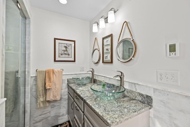 bathroom featuring vanity, tile walls, and a shower with door