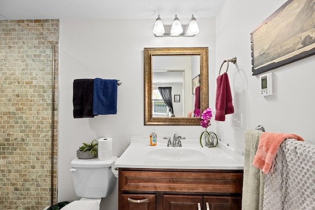 bathroom featuring toilet, a shower with door, and vanity