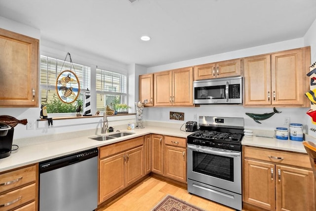 kitchen with stainless steel appliances, light hardwood / wood-style floors, and sink