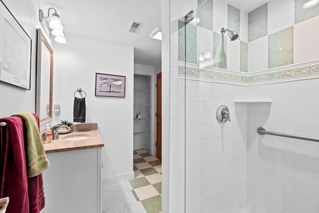 bathroom featuring tiled shower and vanity