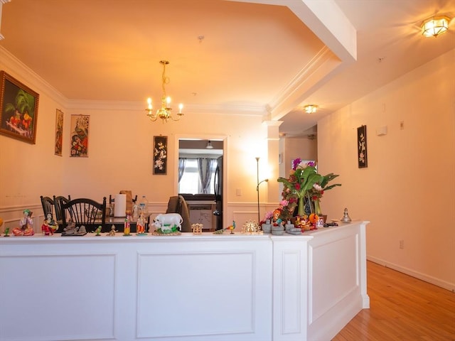 interior space featuring ornamental molding, an inviting chandelier, and light wood-type flooring