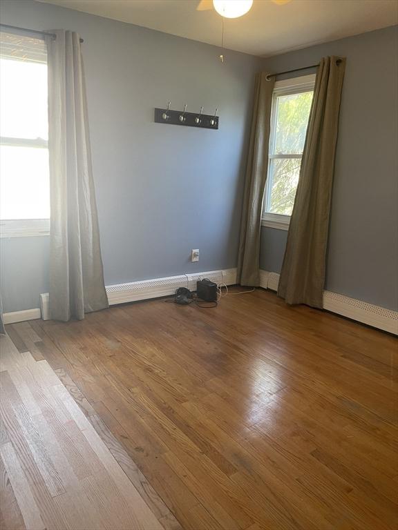 unfurnished room with baseboards, ceiling fan, and wood finished floors