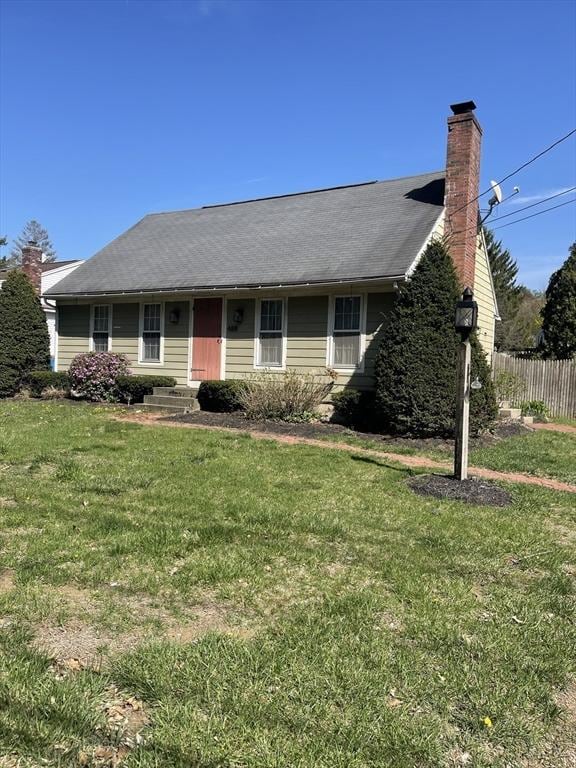 ranch-style house with fence, a chimney, and a front yard