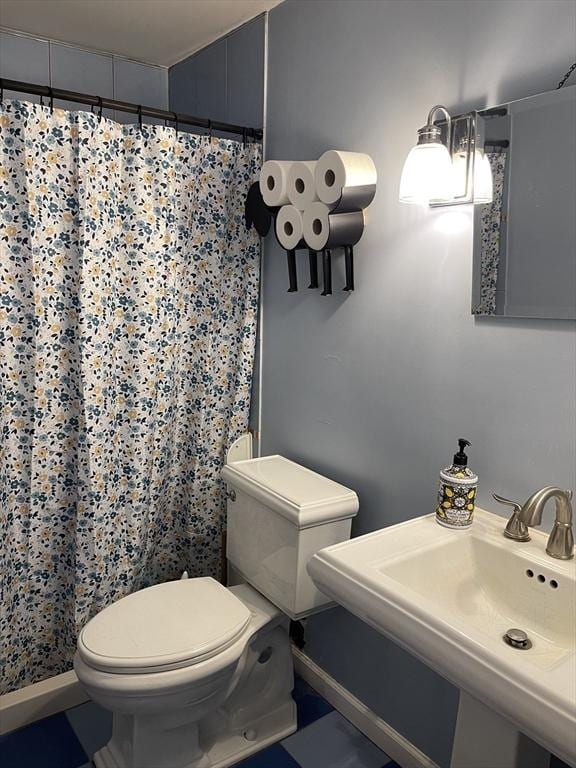 bathroom featuring a sink, a shower with curtain, and toilet