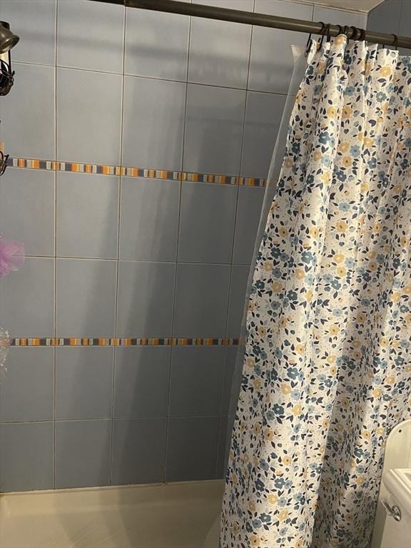 full bathroom with toilet and tiled shower