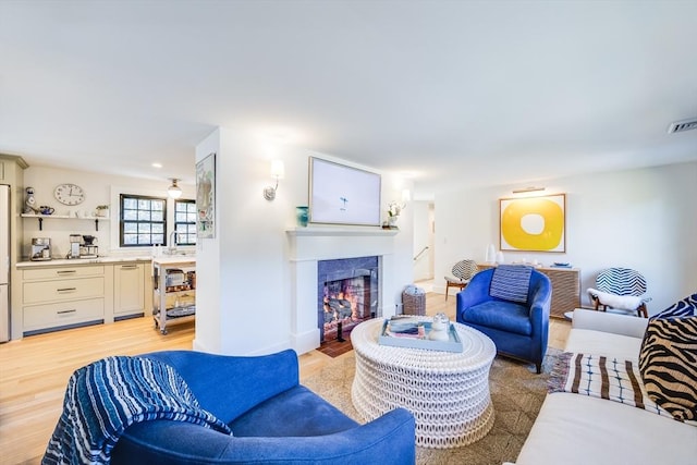 living room with sink and light hardwood / wood-style floors