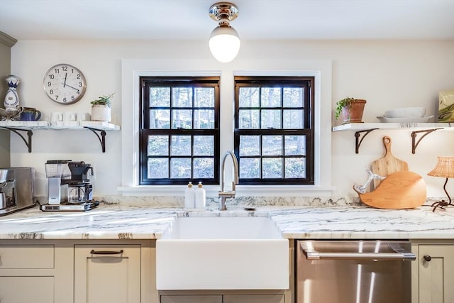 kitchen with light stone countertops, dishwasher, and sink