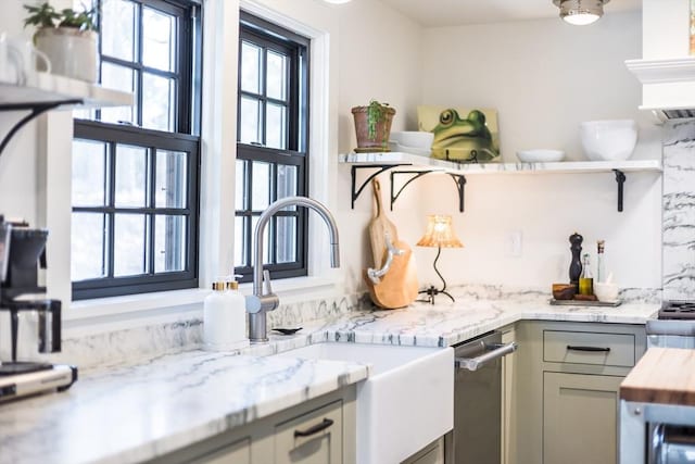 kitchen with light stone counters, sink, gray cabinets, and a healthy amount of sunlight