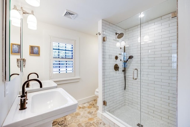 bathroom with toilet, tile patterned flooring, walk in shower, and sink