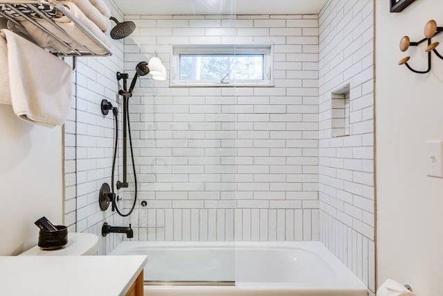 bathroom featuring tiled shower / bath combo and vanity