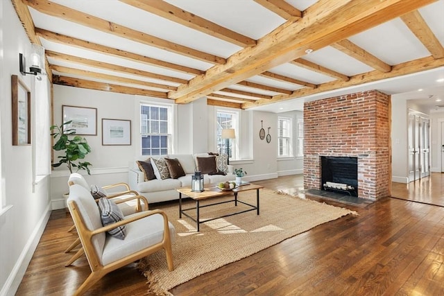 living area with baseboards, beam ceiling, and hardwood / wood-style floors