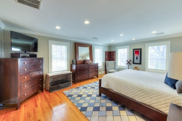 bedroom with multiple windows, visible vents, and light wood-style floors