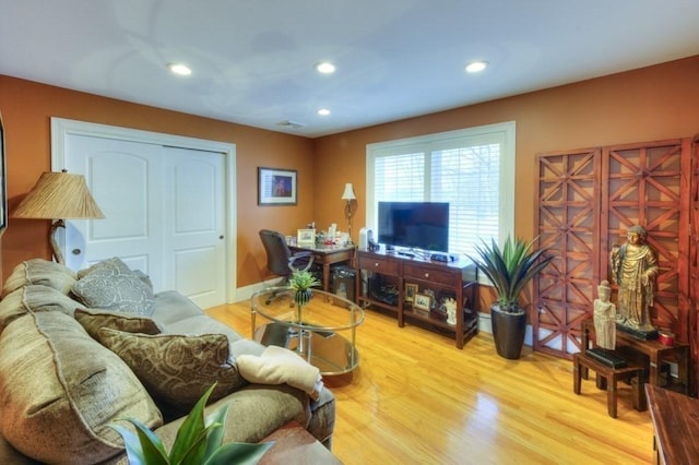 living area featuring recessed lighting, baseboards, and wood finished floors