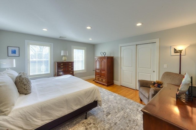 bedroom featuring baseboards, light wood finished floors, a closet, and recessed lighting