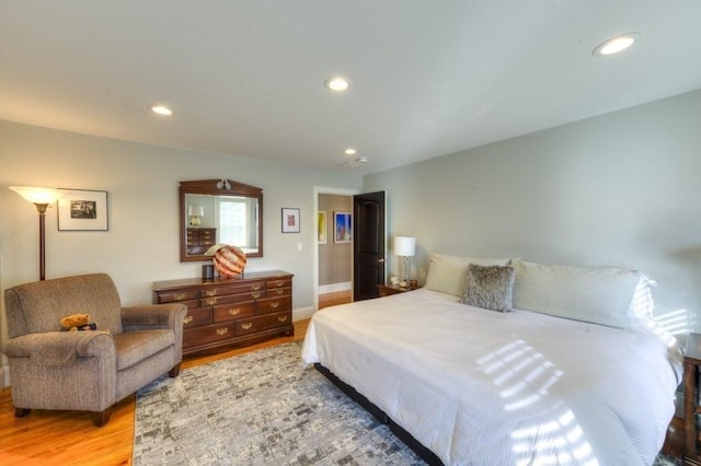 bedroom with light wood-type flooring, baseboards, and recessed lighting