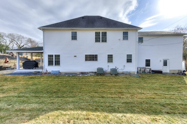 back of house with a patio, an attached carport, central AC, and a yard