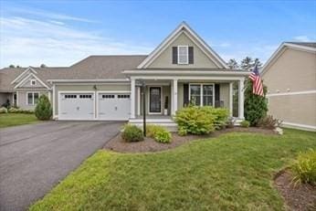 view of front of property with a front yard, a garage, and a porch