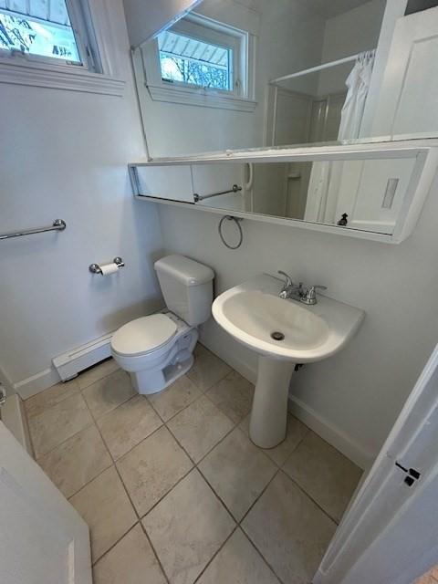 bathroom with tile patterned floors, toilet, baseboards, and baseboard heating