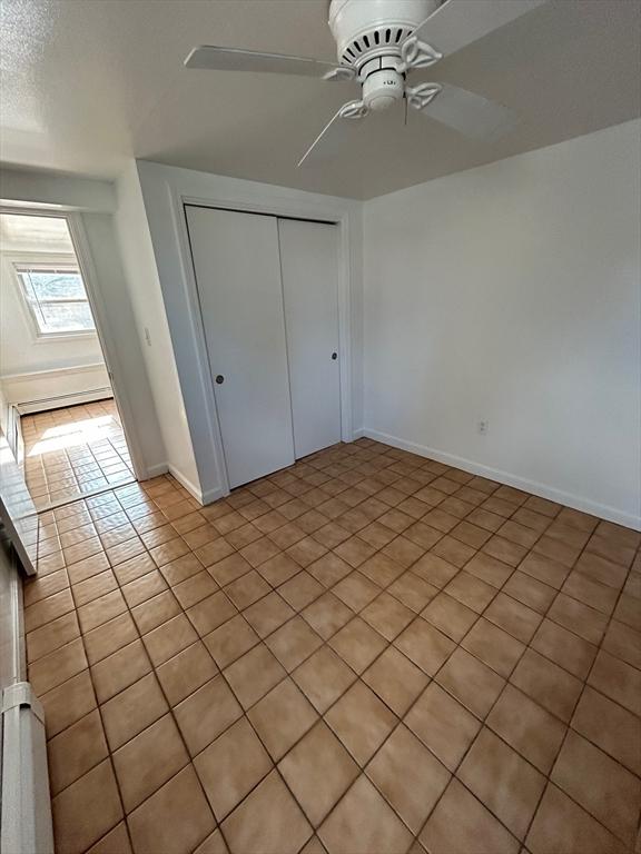 unfurnished bedroom with a closet, baseboards, and ceiling fan