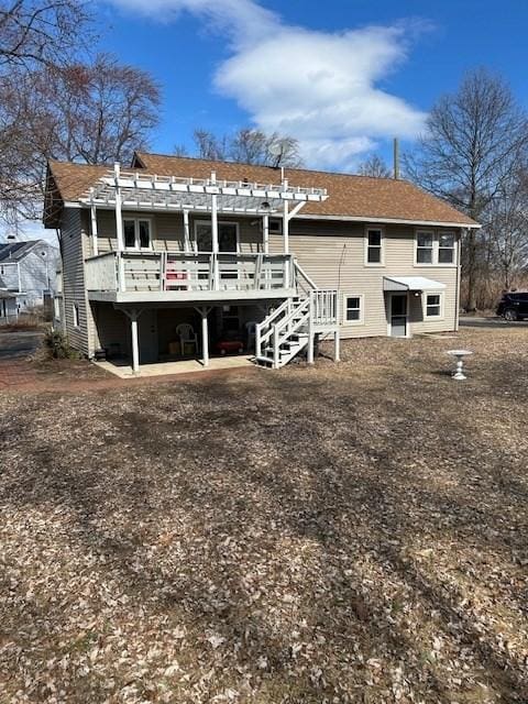 back of property featuring a deck, stairs, and a pergola