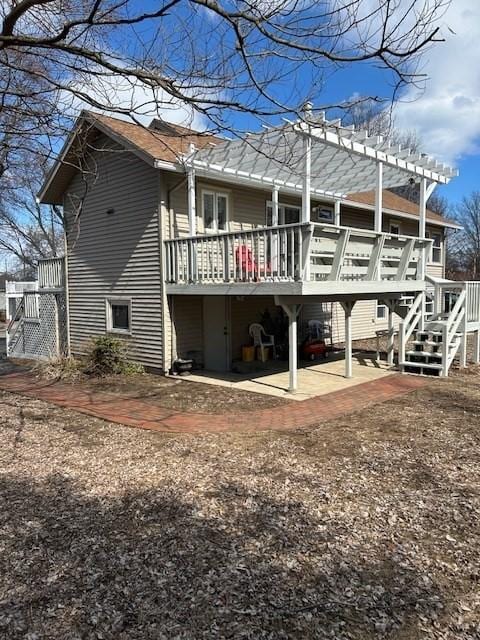 back of property with a deck, stairway, and a pergola