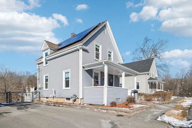 view of home's exterior featuring covered porch and solar panels