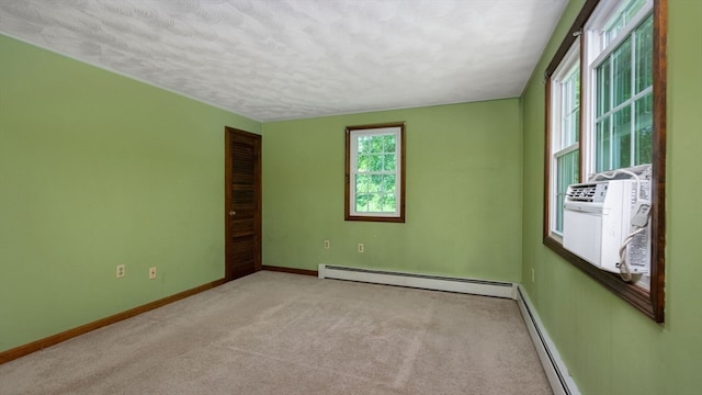 carpeted spare room with a baseboard radiator and a textured ceiling