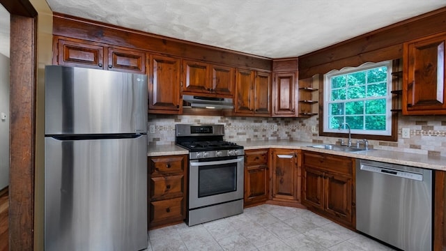 kitchen featuring light stone countertops, sink, stainless steel appliances, and tasteful backsplash