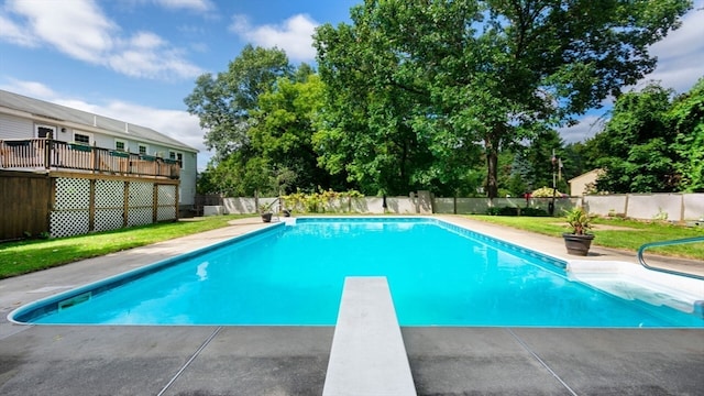 view of swimming pool featuring a diving board and a deck