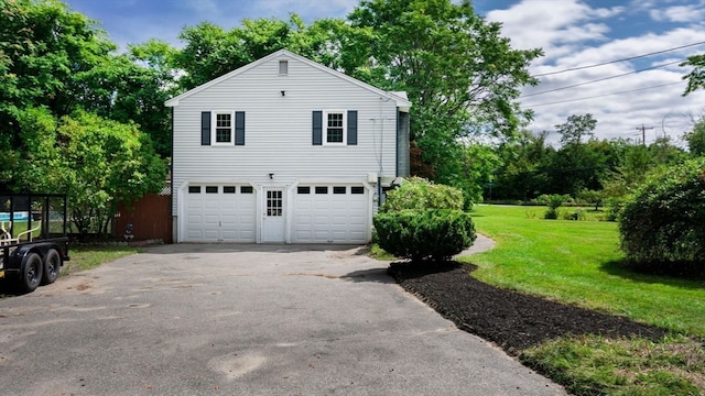 view of side of home with a garage and a yard